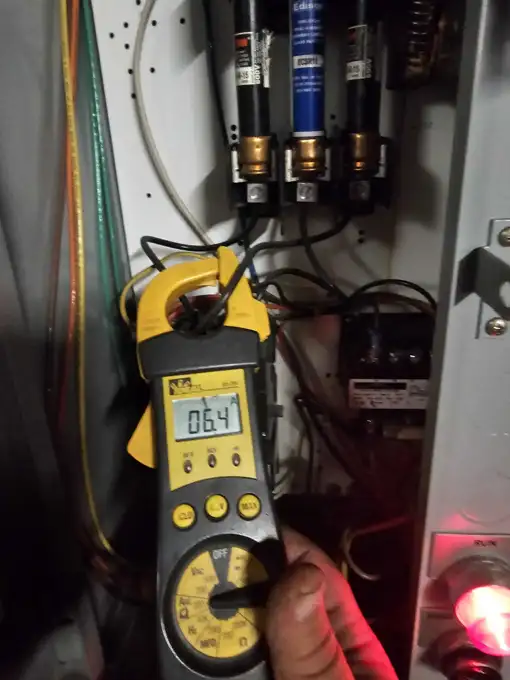 Clamp meter testing a circuit during an electrical inspection